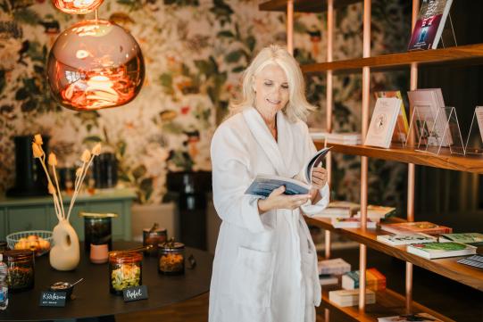 Person im Bademantel liest Magazin